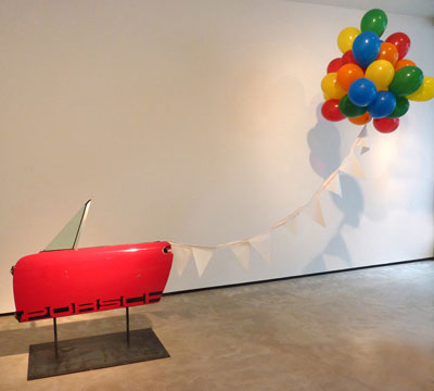 Debra Barrera, Porsche Party, 2012. 1975 Porsche 914 door, steel, pennants, balloons, helium, dimensions variable. Courtesy the artist, Texas Biennial and Moody Gallery.