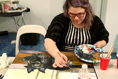 Andi Harman paints a Dubya knockoff during The Paintings of *George W Bush at CentralTrak: The University of Texas at Dallas Artist Residency.