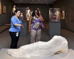 A gallery host and a visitor discuss American artist Karen LaMonte's cast-glass sculpture Reclining Drapery Impression (2009), which has been installed with the Chrysler's antiquities. Photo by Ed Pollard, Chrysler Museum of Art, Norfolk, Va.