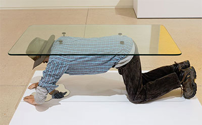 Alejandro Diaz, Muebles (Table), 2015. Cast resin, paint, clothing, hair, glass. 62x32x21 inches.