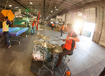 Composer Graham Reynolds accompanies a quintet of forklifts in Goodwill Central Texas warehouse for Forklift Danceworks RE Source. Photo by Amitava Sarkar.