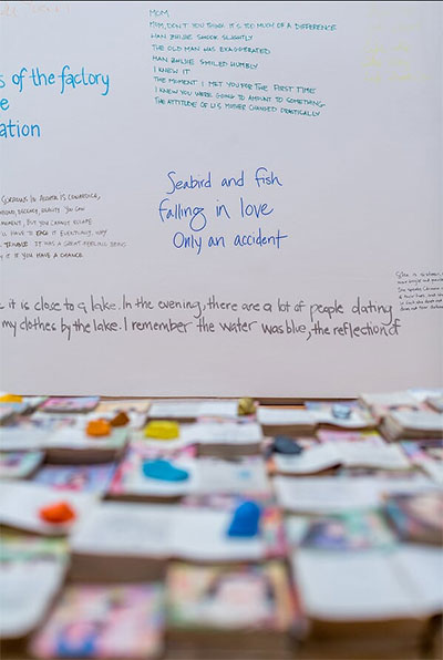 Liu Chuang, Love Story (1), 2006-2014. Found books, artist-colored rocks, wooden platform, and handwritten text on wall. Courtesy of the artist and Salon 94, New York. Photo by Alex Barber.