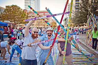 Sculptor Patrick Renner with Flying Carpet’s Nick Moser and Kelly O'Brien at the painting party for Trumpet Flower. Photo by Morris Malakoff.